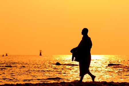Silhouettes of monks on the beach,Hua Hin Thailandの写真素材