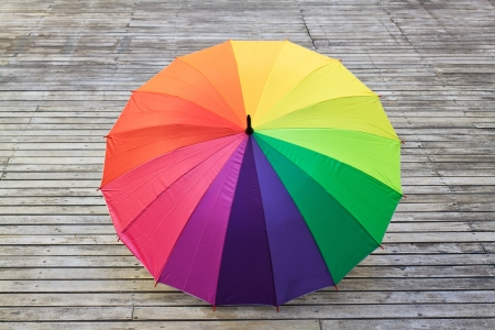Multi-colored umbrella on wood  background の写真素材