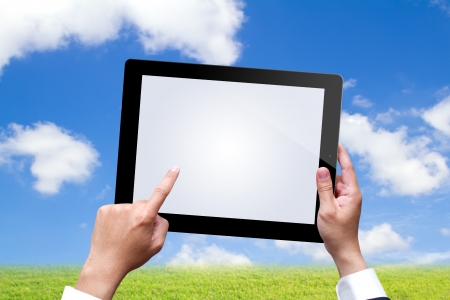 male hands holding a tablet on blue skyの写真素材