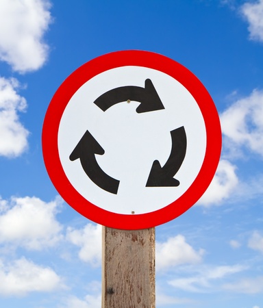 Roundabout Road Sign for Traffic on blue skyの写真素材