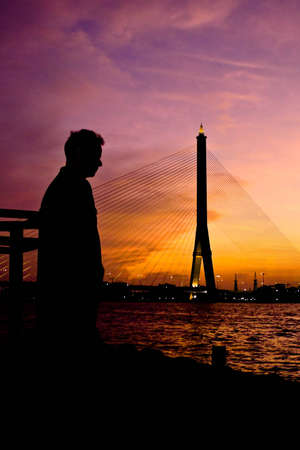Lonely man on the pier in colorful twilight.の写真素材