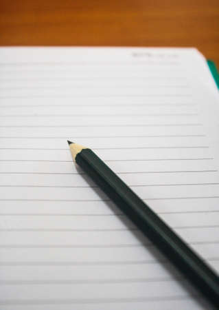 Pencil on the notebook it s blurs it s on the table の写真素材