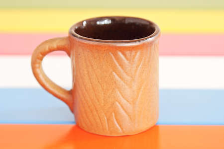 Brown cup on color table.の写真素材