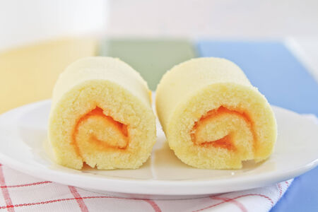 Orange roll cake on white plateの写真素材