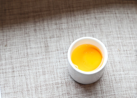 Raw egg in white cup.の写真素材