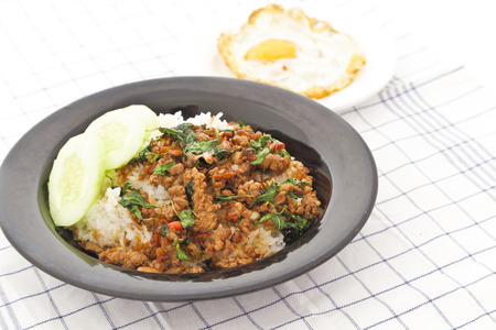 Thai stir-fried chicken and basil served with rice and fried eggの写真素材