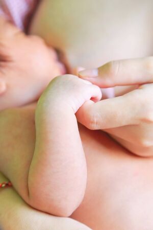 Hand of the child in a hand of mother and Mother feeding baby.の写真素材