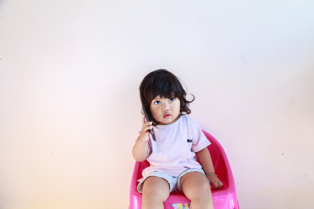little girl playing with mobile phones.の写真素材