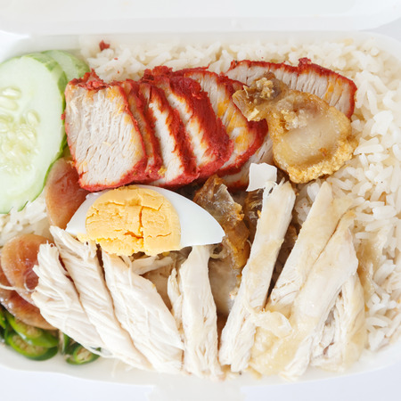 Rice steamed with chicken soup crispy pork roasted red pork and boiled egg.の写真素材