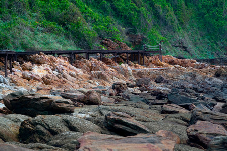 An old wooden bridge on the edge of a rocky mountain during the dayの写真素材