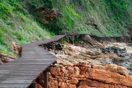 An old wooden bridge on the edge of a rocky mountain during the dayの写真素材