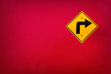 Old Yellow traffic sign "Turn right" on red wall textureの写真素材