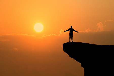 Man on top of mountain ,Freedom man on sunset backgroundの写真素材
