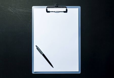 Clipboard and pen with white sheet on black background. Top view. mock up for word.