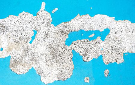 The wall is painted blue with cracks in the color of gliding. Use for design and background.の写真素材