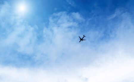 Airplane in the sky on a background of blue sky and white clouds.