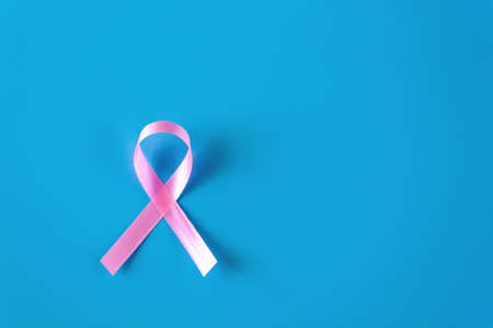 Pink Breast cancer ribbon isolated on blue background. with blank copy space.の写真素材