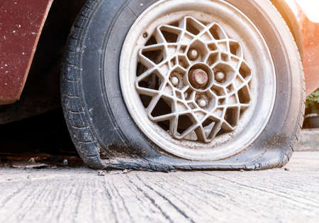 Old tires that are flat, have cracks attached to the wheels of the car.