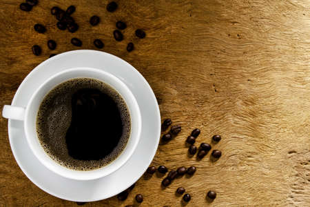 Top view, black coffee with coffee beans on wooden table background. Concept of drinking coffee and relaxingの写真素材