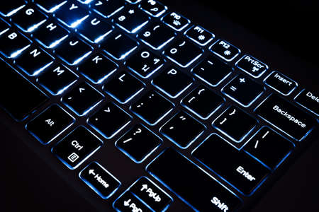 Close up of black keyboard of a modern laptop, Illuminated keyboard keys computerの写真素材