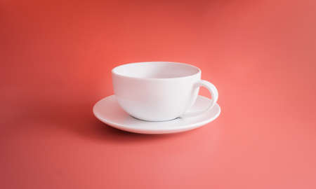 White coffee cup isolated on orange pastel background or orange backdropの写真素材