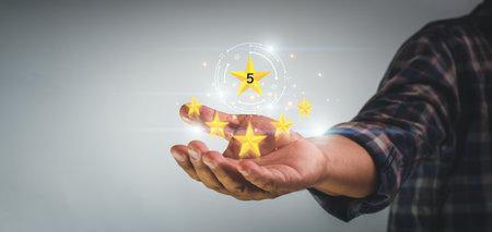 Satisfaction survey concept, Businessman holding golden five stars for client customer feedback and evaluation product and service best quality, giving a five star rating, Service rating conceptの写真素材