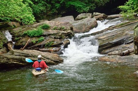 An older man looking at a waterfall on Lake Jocassee in South Carolina.の写真素材