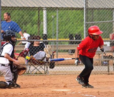 Cumming GA, Forsyth County - April 19, 2010 - A baseball game of boys 10-12 years old, the Bulldogs vs White Raiders. Batter after a hit.のeditorial素材