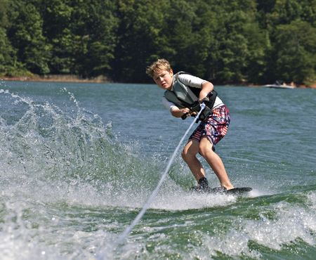 A young boy doing a side slide on his trick ski.の写真素材