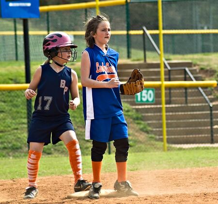 Cumming, GA, USA - April 18 : Young girl (8 years old) holding the runner on base during a softball game. Forsyth County, Cumming GA, April 18, 2009, a regular season game of the Lady Gators vs the Bennet Park Blues.のeditorial素材