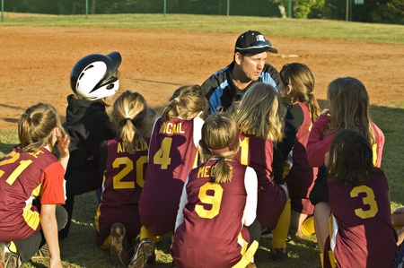 Cumming, GA, USA; April 16, 2011  - A coach talking to the girls on his team in Forsyth County, Cumming GA for a regular season game between the Diamonds and the Warriors.のeditorial素材