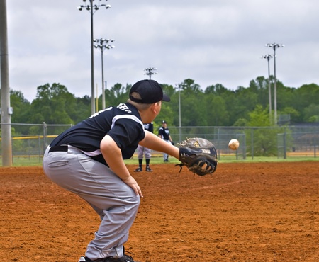 CUMMING, GA, USA - APRIL 23: Young baseball player catching the ball in Forsyth County, Cumming GA,...