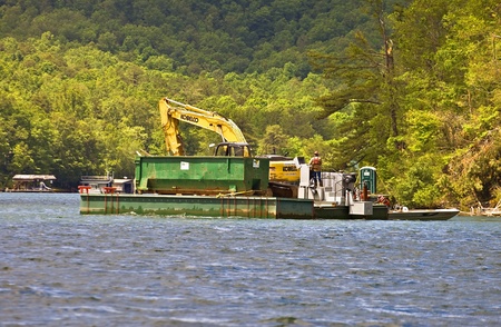 CLAYTON, GA, USA - May 15 : Unidentified workers cleaning up after a tornado on May, 15, 2011, Lake Burton, Rabun County, Clayton, GA, barge and equipment.のeditorial素材