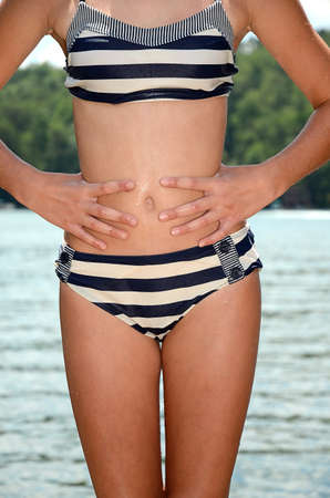 A girl posing in a bikini with hands at waist 