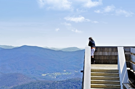 A young boy on an observation tower looking out over the mountains at Brasstown Bald in Georgia.の写真素材