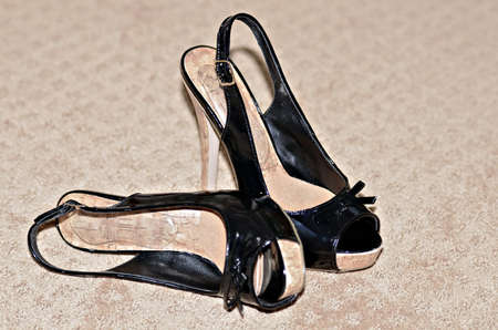 A pair of ladies fashion shoes on a carpet 
