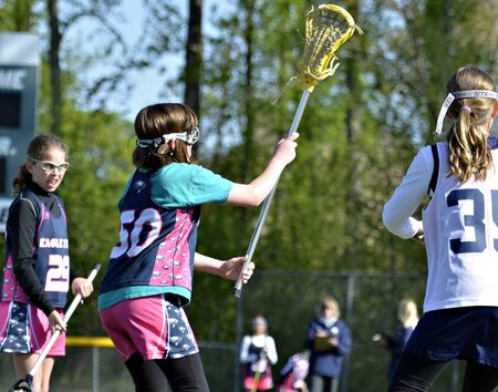 CUMMING, GA - APR 20: Newtown Eagles and West Forsyth Wolverines girl's lacrosse teams in a game on April 20, 2013 in Cumming, GA.のeditorial素材