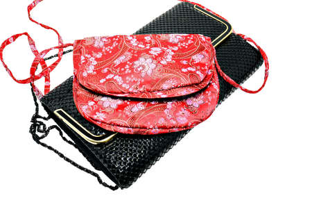Two decorative clutch bags, red print silk fabric, and black.の写真素材