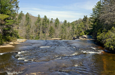 A mountain river flowing over the rocks down to a waterfall の写真素材