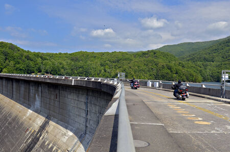 A group of motorcycles riding across the Fontana Dam のeditorial素材