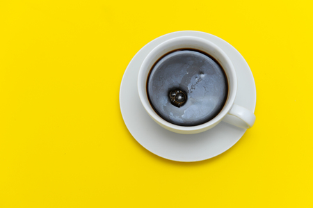 Black coffee in a white cup and on a yellow background.の写真素材