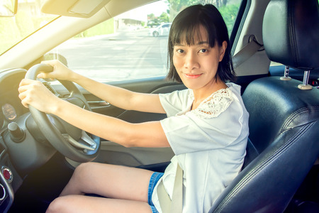 Asian girl is about to drive away, wearing a neat belt.の写真素材