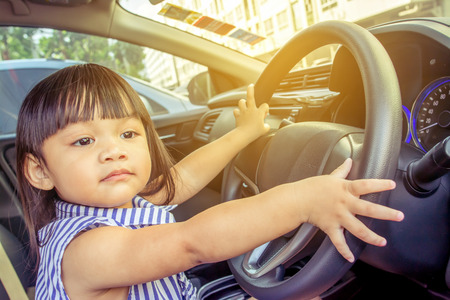 Cute little girl, steering wheel.の写真素材