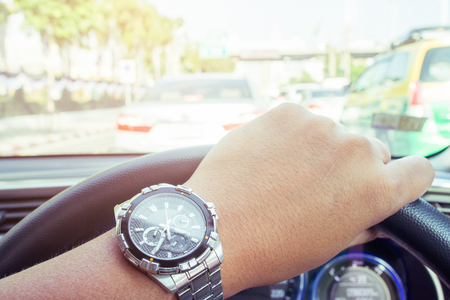 Looking at the clock while driving because of hustle to work.の写真素材