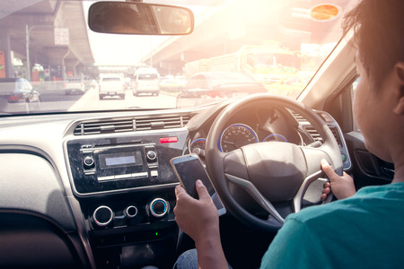 Man driving and calling, dangerousの写真素材