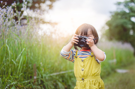 Little Asian girl is taking a photo.の写真素材