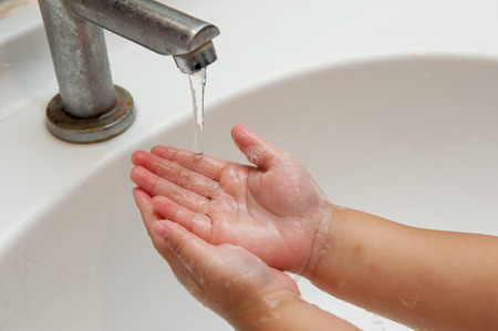 Baby is washing his hands. In the sink.の写真素材