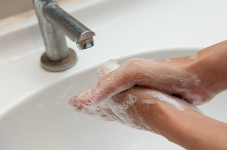 People are washing their hands in the sink. With soap.の写真素材