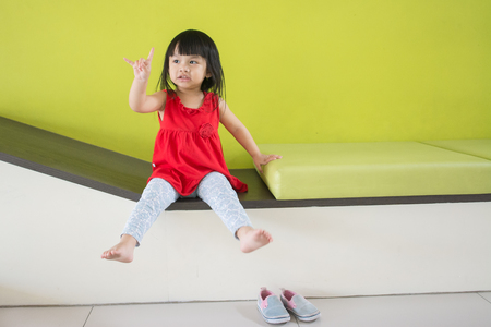Asian little girl, sitting in a room, a child model taking picturesの写真素材