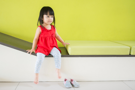 Asian little girl, sitting in a room, a child model taking picturesの写真素材